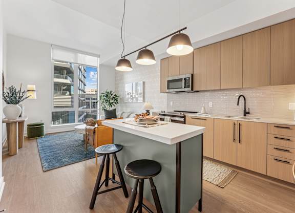 A kitchen with a white countertop and wooden cabinets.