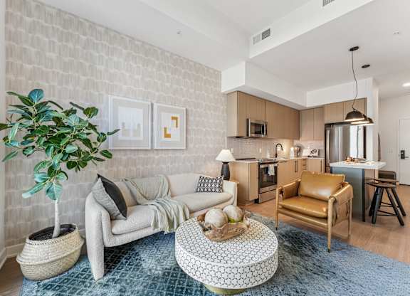 A living room with a white brick wall and a grey sofa.