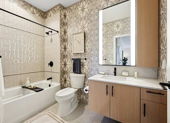 A bathroom with a white tub, toilet, and sink.
