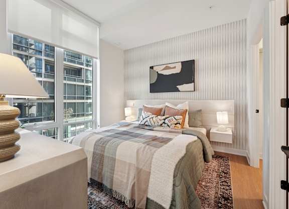 A bedroom with a large bed and a painting above it.