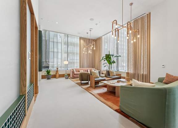A lobby with a green sofa and a wooden floor.
