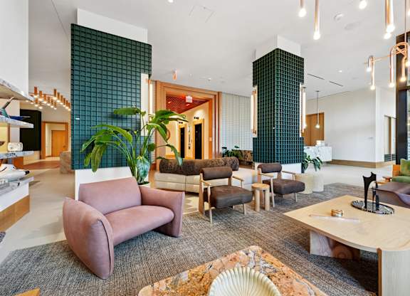 A modern living room with a variety of seating options and a large window.