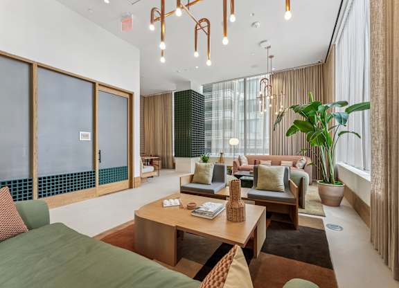 A lobby with a green sofa and a wooden coffee table.