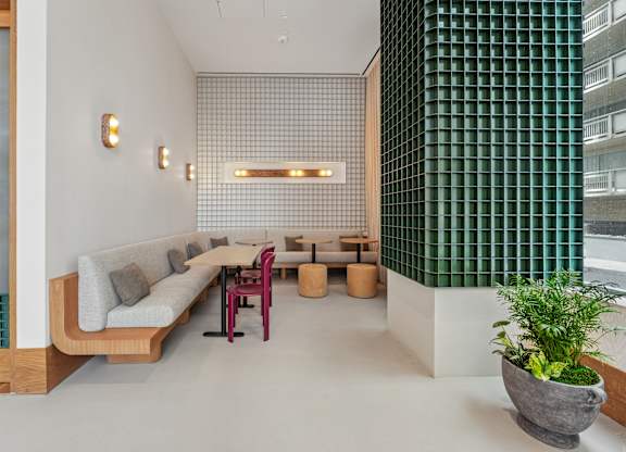 A modern living room with a long couch and a green wall.