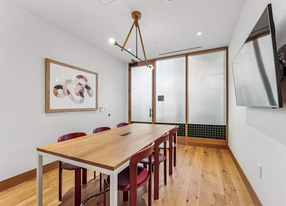 A dining room with a wooden table and chairs.