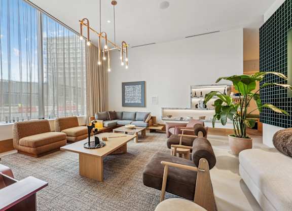 A modern living room with a large window and a variety of seating options.