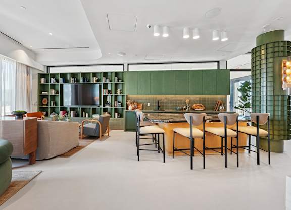 A modern kitchen with green cabinets and a dining table set for four.