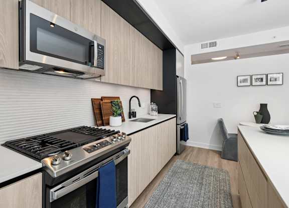 A modern kitchen with a stove top oven and microwave above it.