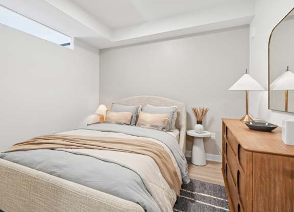 A bedroom with a bed, nightstand, and lamp.
