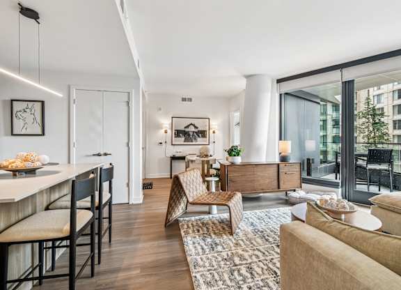 A modern living room with a dining area and a view of a building outside.