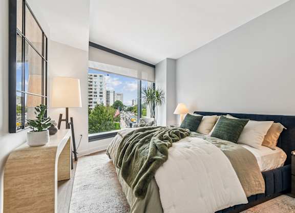 A bedroom with a large bed and a view of the city.