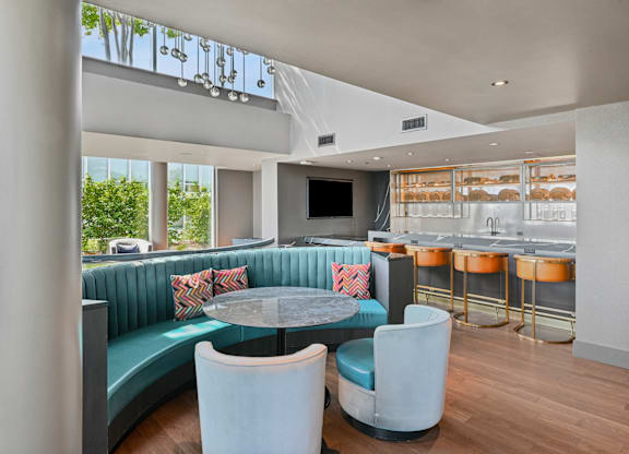 A modern dining area with a round table and blue chairs.