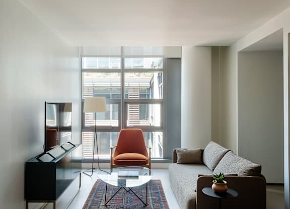 A living room with a brown chair and a brown couch.