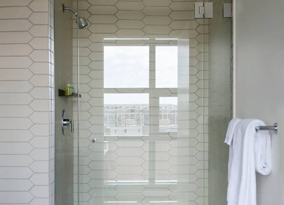 A white towel is hanging on a towel rack in a bathroom.