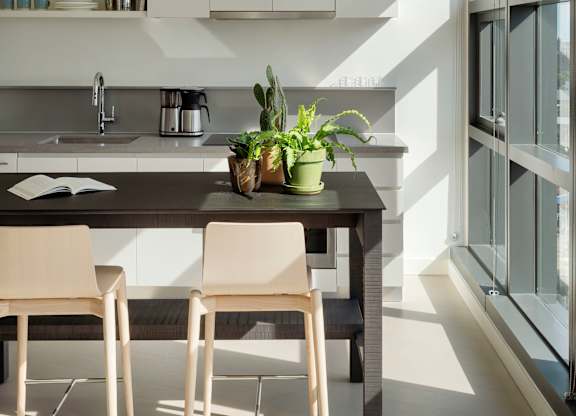 A kitchen with a table and chairs.