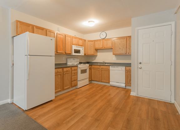 A kitchen with wooden cabinets and a white refrigerator.