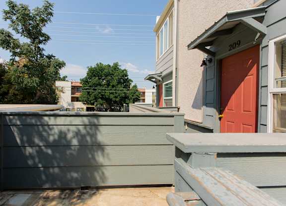 A house with a red door and a grey wall.