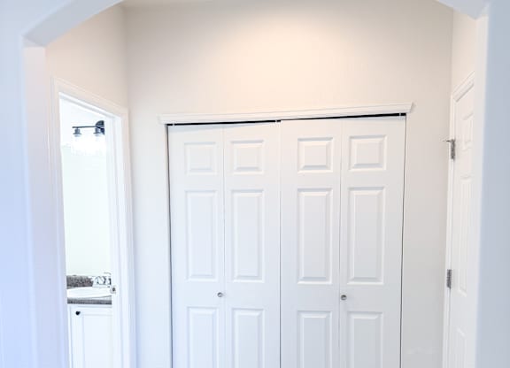 A white double door is in a white archway.