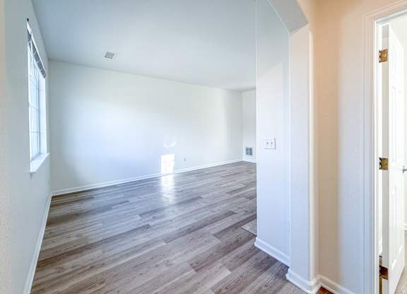A room with wooden flooring and white walls.