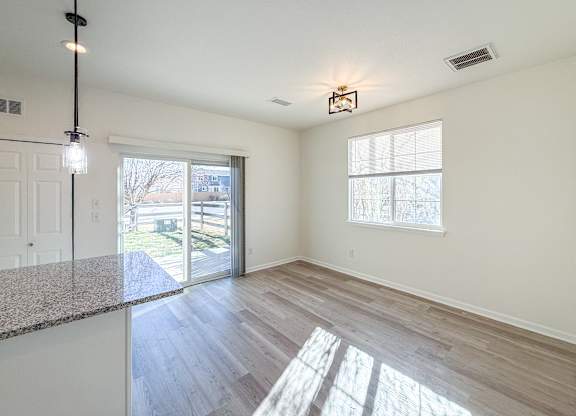 A sunny day in a spacious room with a marble countertop and a window.