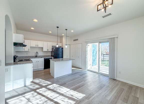 A kitchen with white cabinets and a large island.