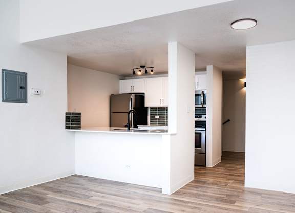 A kitchen with a refrigerator, oven, and microwave.