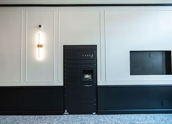 A black LUXEER vending machine sits in a corner of a room.
