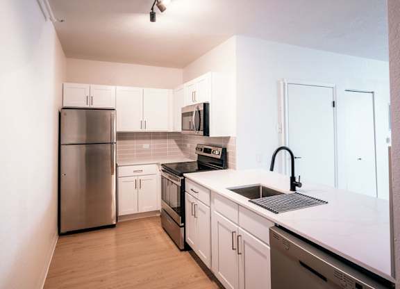 A kitchen with white cabinets and stainless steel appliances.