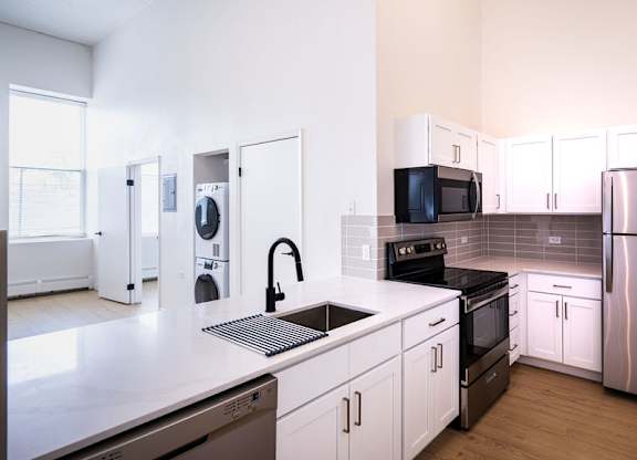 A kitchen with white cabinets and stainless steel appliances.