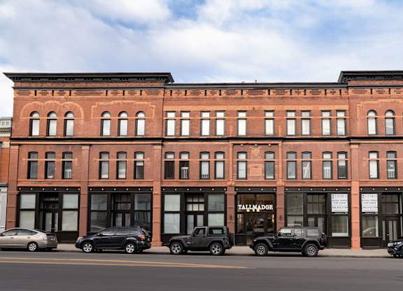 A red brick building with cars parked in front.