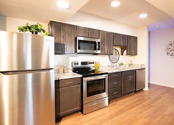 A modern kitchen with a stainless steel refrigerator and wooden cabinets.at 891 Exchange, Colorado