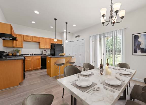 A modern kitchen with a dining table set for two.