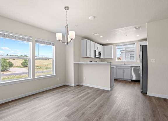 Kitchen with white cabinets and a wooden floor at The Townhomes at Pine Drive, Parker, 80138