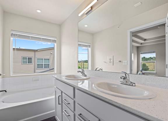 Modern bathroom with a large tub and double sinks at The Townhomes at Pine Drive, Parker, CO, Colorado