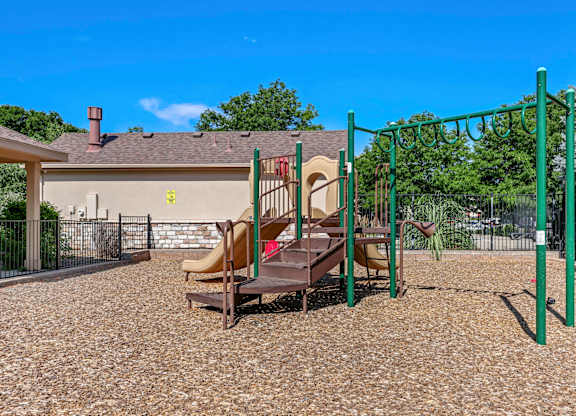 A playground with a slide and swings in a residential area.