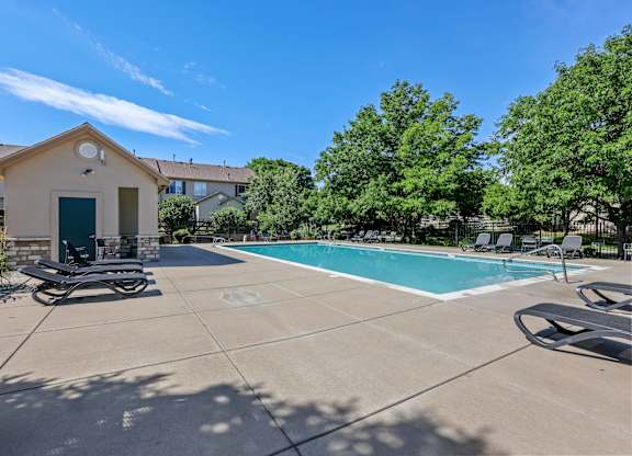 A pool area with a small building and a bicycle.