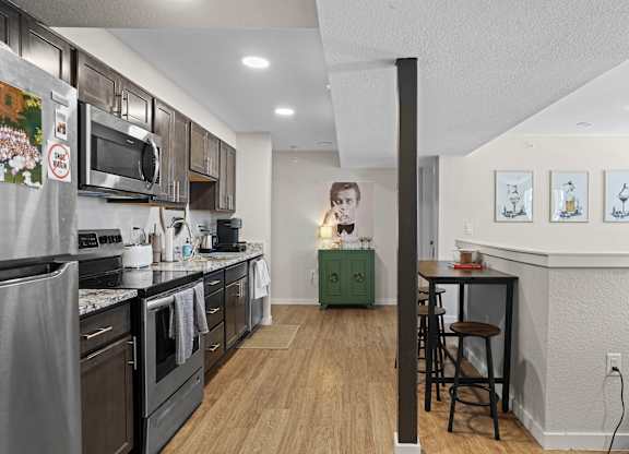 A woman is standing in a kitchen with a green cabinet.