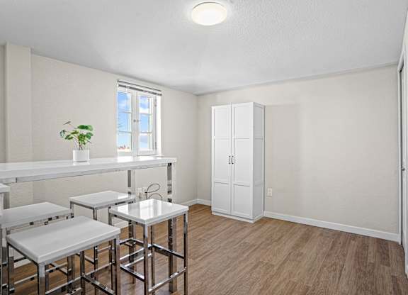 A white kitchen with a bar and stools.