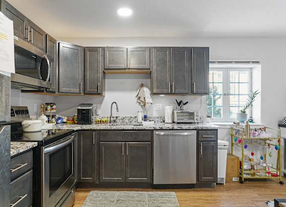 A kitchen with dark wood cabinets and stainless steel appliances.
