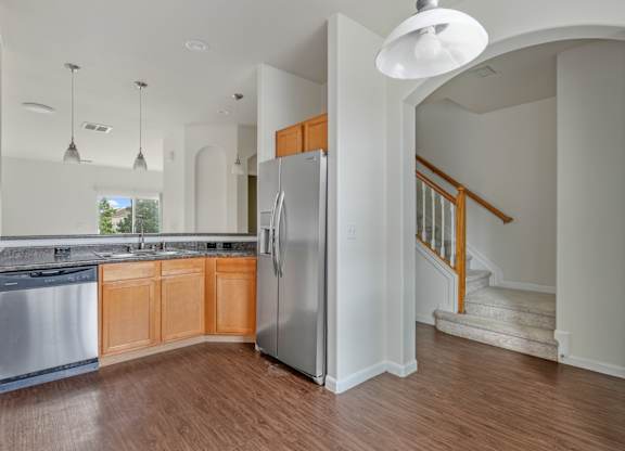 A kitchen with a refrigerator and a stainless steel dishwasher.