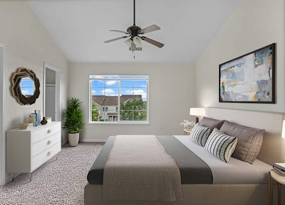 A bedroom with a large bed and a ceiling fan.