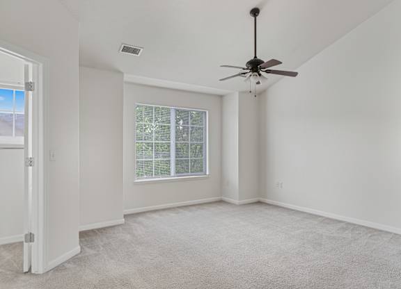 A room with a ceiling fan and a window with blinds.