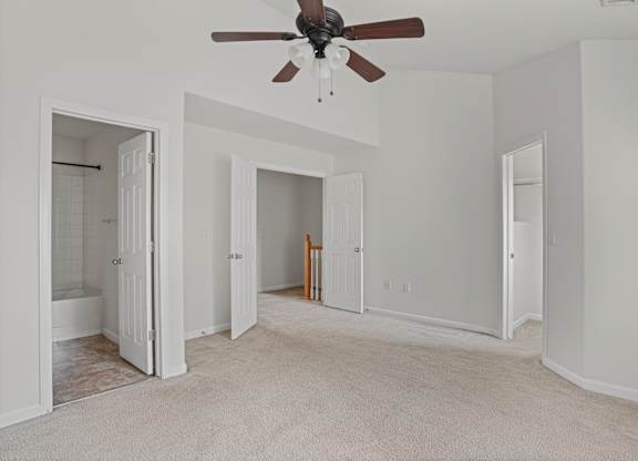 A room with a ceiling fan and carpeted floor.