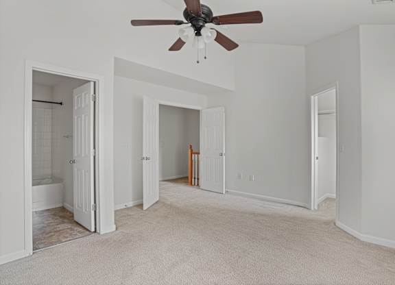 A room with a ceiling fan and carpeted floor.