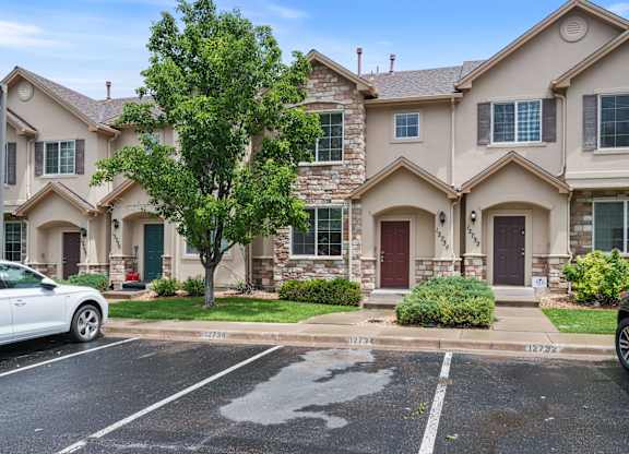 A row of houses with a car parked in front of them.