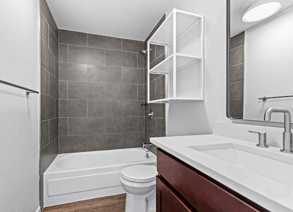 A white toilet sits next to a white sink in a modern bathroom.
