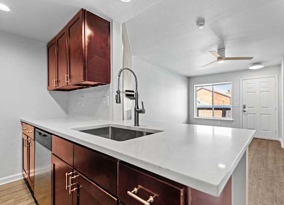 A kitchen with a white countertop and copper cabinets.