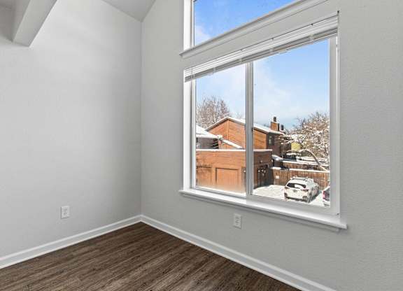 A room with a large window overlooking a snowy landscape.