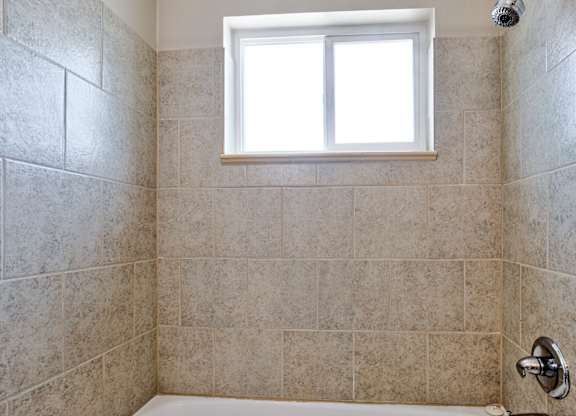 bathroom with a tiled wall at Kingsbrook Arms, Englewood, 80113