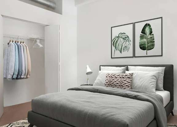 A bedroom with a large bed and two framed leaves on the wall.